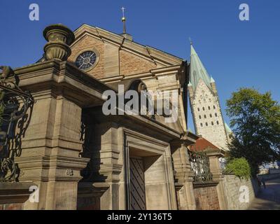 Chiesa storica con una suggestiva cupola, dettagli in pietra e circondata da alberi sotto un cielo blu, paderborn, Renania settentrionale-Vestfalia, germania Foto Stock