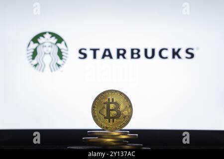 Slovenia, Lubiana, 02 24 2019: Bitcoin su una pila di monete con il logo Starbucks sullo schermo di un laptop, Europa Foto Stock