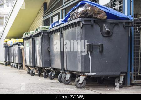 Traboccante cassonetti con i rifiuti domestici in città Foto Stock