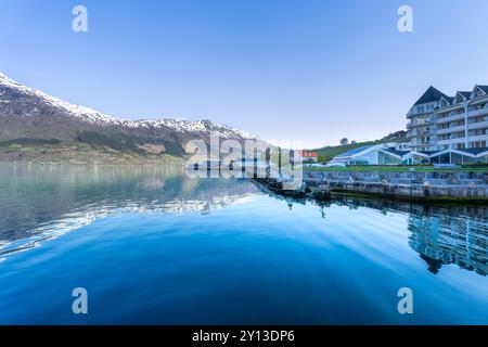 Un tranquillo villaggio adagiato sulla costa dell'Hardangerfjord. Il contrasto tra le case bianche e le calme acque turchesi è impressionante. Voss, Foto Stock