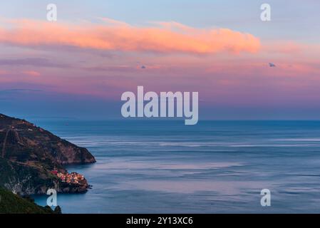 Il villaggio di pescatori di Manarola nelle cinque Terre, in Italia, al tramonto con il Mar Mediterraneo come sfondo Foto Stock