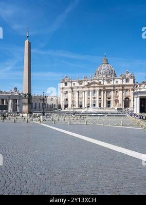 I visitatori potranno godersi una giornata di sole in Piazza San Pietro, ammirando l'imponente architettura della basilica di San Pietro e l'imponente obelisco sotto un cielo azzurro. Foto Stock