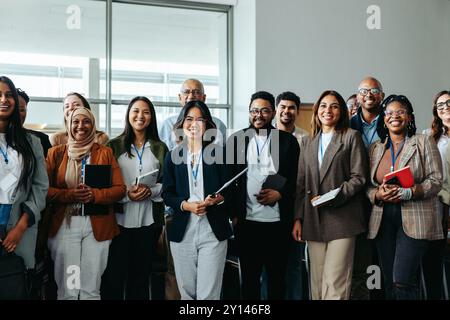 Gruppi diversi di professionisti, tra cui dipendenti, uomini d'affari e donne d'affari, sorridono in una conferenza. Foto Stock