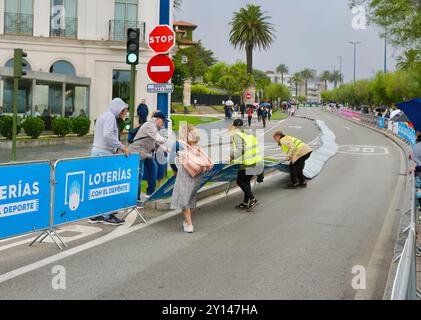 In attesa di ciclisti nella 17a tappa della Vuelta de Espana con barriere soffiate da una raffica di vento Santander Cantabria Spagna 4 settembre 2024 Foto Stock