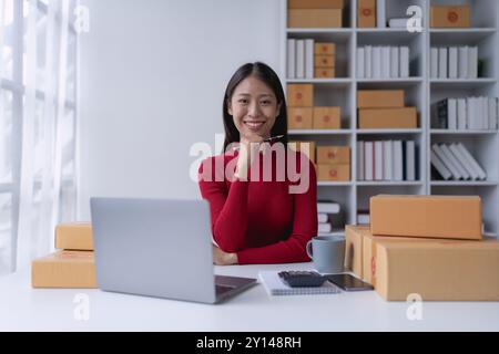 Una donna, venditrice online, raggiunge il successo delle vendite utilizzando un tablet, gli obiettivi e favorisce il successo nella sua attività di e-commerce. Foto Stock