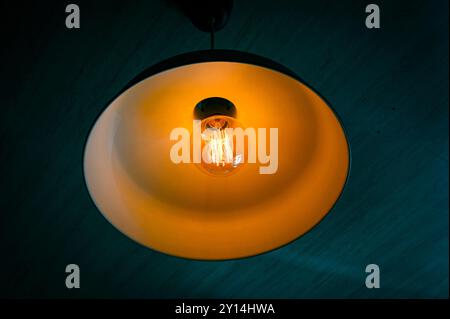 Close-up of glowing bulb lampshade with yellow light Foto Stock