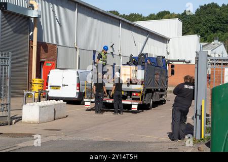 Vista posteriore di una guardia di sicurezza femminile all'ingresso di un'area industriale. Foto Stock