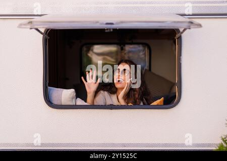 Persone e destinazione di vacanza di viaggio. Felice giovane donna adulta sorriso e godere della natura fuori strada parcheggio fuori dalla finestra del suo motore moderno Foto Stock