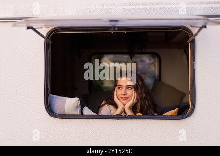 Persone e destinazione di vacanza di viaggio. Felice giovane donna adulta sorriso e godere della natura fuori strada parcheggio fuori dalla finestra del suo motore moderno Foto Stock