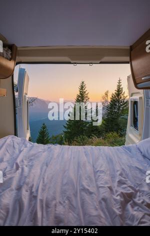 Mentre l'alba si infrangono sulle montagne, la luce soffusa inonda attraverso le porte aperte, rivelando panorami mozzafiato. Un letto accogliente vi attende, invitante relax in mezzo allo splendore della natura a Hallstatt. Foto Stock