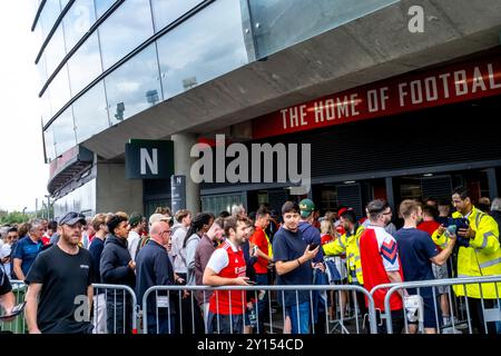 I tifosi dell'Arsenal Football fanno la fila per Un controllo di sicurezza prima di entrare all'Emirates Stadium, Londra, Regno Unito. Foto Stock