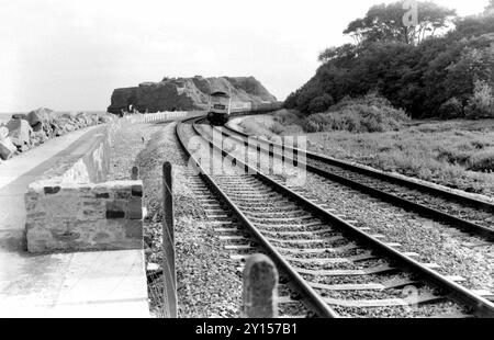 Locomotiva diesel British Rail Class 47 che trasporta un treno dietro un angolo verso Dawlish Warren, Bideford, Devon, UK, lungo il percorso della costa sud-occidentale nell'estate 1972. Langstone Rock in sottofondo. Foto Stock