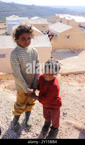 Aleppo, Siria. 21 febbraio 2023. Bambini nei campi di sfollamento per sopravvissuti al terremoto nella città siriana di Darat Izza, nella campagna occidentale di Aleppo. Più di 250 famiglie di Jenderis e di altre città del nord-ovest della Siria colpite dal terremoto hanno cercato rifugio nei campi improvvisati. I terremoti che hanno colpito Turkiye e Siria il 6 febbraio 2023 hanno colpito pesantemente la Siria nord-occidentale Foto Stock