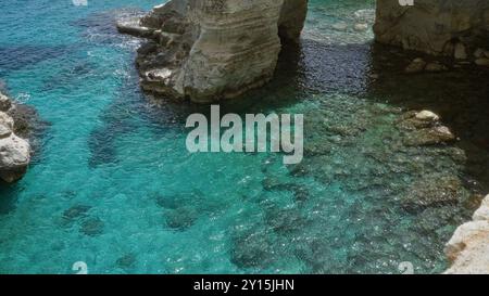 Una splendida vista delle limpide acque turchesi e delle formazioni rocciose di torre dell'orso, salento, puglia, italia, che mostra la bellezza naturale della medite Foto Stock