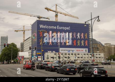 Striscione / avvolgimento su Haus der Statistik 'Benvenuti in Europa! Sportmetropole Berlin' + Berlino ha i colori delle nazioni Euro2024; gru da costruzione Foto Stock