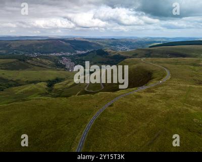 Veduta aerea di una strada tortuosa che conduce attraverso prati verdi nelle valli del galles Foto Stock