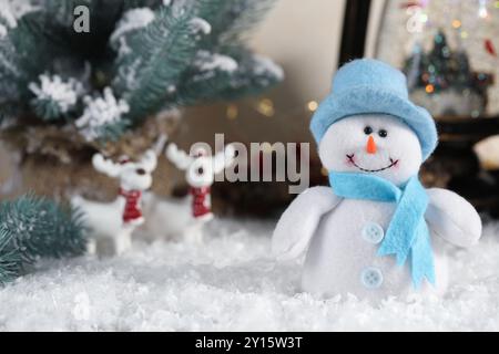 Divertente personaggio di pupazzo di neve e decorazioni natalizie sulla neve artificiale Foto Stock