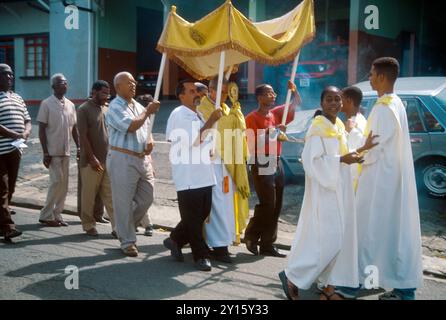 Tobago Trinidad Corpus Christi Processione con prete che porta un mostranza e ragazzi che trasportano il Thurible (bruciatore con incenso sospeso) Foto Stock