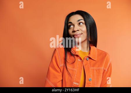 Una giovane donna elegante trasuda fiducia con un'espressione giocosa. Foto Stock