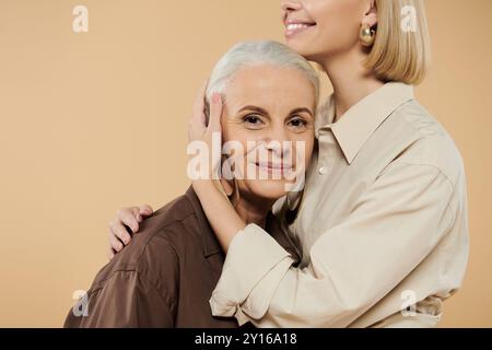 Una donna matura gode di un tenero abbraccio con la figlia adulta. Foto Stock