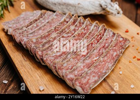 Primo piano di salame salato a fette a bordo, ideale per piatti gourmet e presentazioni di salumi Foto Stock