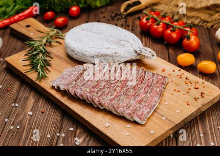 Primo piano di salame salato a fette a bordo, ideale per piatti gourmet e presentazioni di salumi Foto Stock