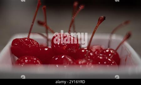 Primo piano di ciliegie rosse brillanti in una ciotola bianca Foto Stock