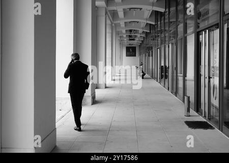 Persone che guardano a Lisbona, fotografie di strada - uomo in tuta nei locali di Seaway nella zona commerciale della sponda del fiume Tago. Foto Stock