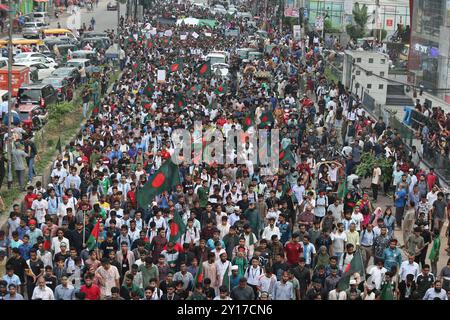 Dhaka, Wari, Bangladesh. 5 settembre 2024. I manifestanti inondano la bandiera nazionale del Bangladesh durante la marcia dei martiri, una manifestazione organizzata dagli studenti contro la discriminazione per celebrare un mese per l'estromissione dell'ex primo ministro Sheikh Hasina, a Dacca il 5 settembre 2024. L'ex Premier del Bangladesh Sheikh Hasina dovrebbe "tacere" mentre era in esilio in India fino a quando non viene portata a casa per il processo, il leader ad interim Muhammad Yunus ha detto ai media indiani il 5 settembre. Hasina, 76 anni, fuggì in India in elicottero un mese fa mentre i manifestanti marciavano sul suo palazzo in una drammatica fine al suo dominio pugnalato di ferro Foto Stock