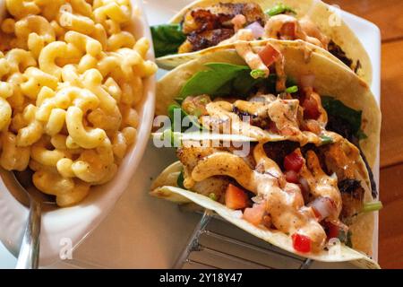 Tacos di pesce appena serviti con Mac e formaggio Foto Stock