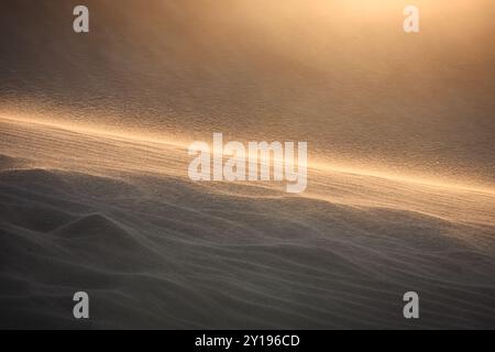 Il sole tramonta mentre i forti venti soffiano sabbia sulle dune del White Sands National Park vicino ad Alamogordo, New Mexico. Foto Stock