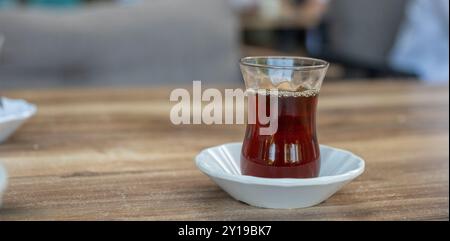 Bicchiere di tè turco sul tavolo in un classico bicchiere e piattino Foto Stock