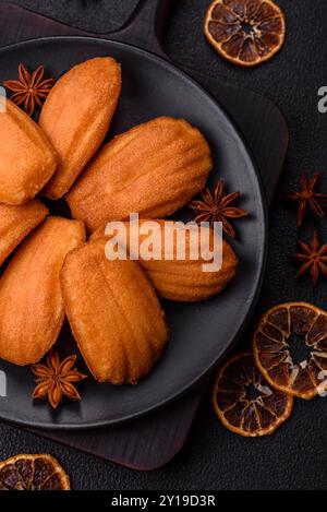 Tradizionali biscotti francesi madeleine con sapore di nocciola su sfondo di cemento scuro Foto Stock