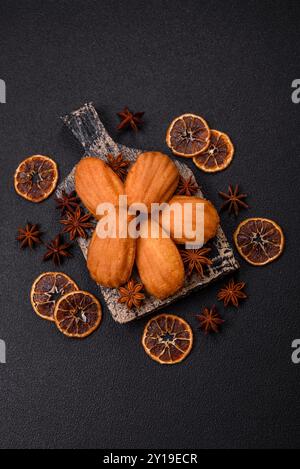 Tradizionali biscotti francesi madeleine con sapore di nocciola su sfondo di cemento scuro Foto Stock