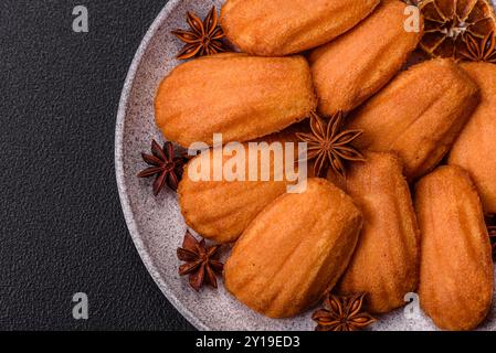 Tradizionali biscotti francesi madeleine con sapore di nocciola su sfondo di cemento scuro Foto Stock