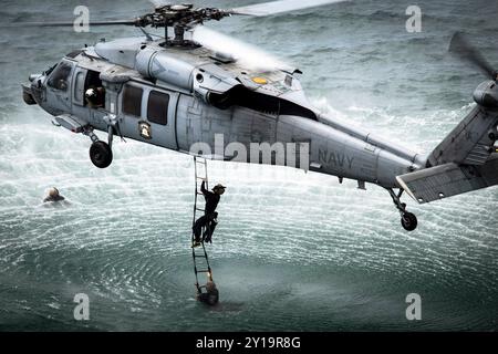 I tecnici addetti allo smaltimento degli ordigni esplosivi tornano sull'aeromobile MH-60S Seahawk come parte dell'addestramento al cast di elicotteri Foto Stock