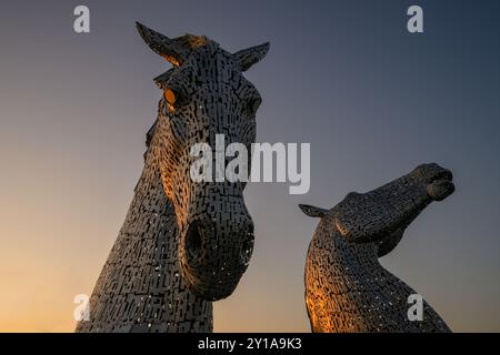 Iconica attrazione turistica scozzese, le sculture Kelpies a Helix, Grangemouth, Falkirk, Scozia, Regno Unito in condizioni di scarsa illuminazione al tramonto Foto Stock