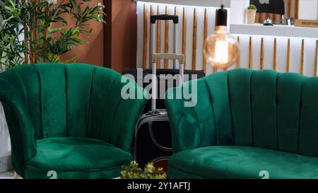 Elegante area lounge con mobili lussuosi presso il resort dell'hotel, ingresso della lobby vuoto e banco ricevimento presso il ricevimento. Splendido spazio elegante che crea un'atmosfera confortevole per ospiti e clienti. Foto Stock