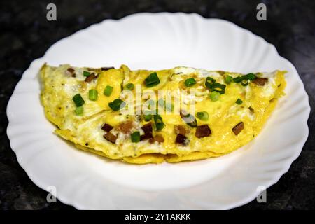 Omelette tradizionale con pancetta e erba cipollina, cibo vero, proteine forti e nutrienti Foto Stock