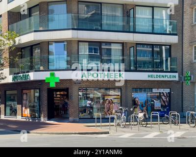 Knokke-Heist, Fiandre, Belgio - 24 giugno 2024: Farmacia Heldenplein con le biciclette davanti. Poster colorati nelle finestre di esposizione Foto Stock