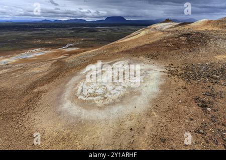 Sorgenti termali e area geotermica di fronte al paesaggio montano in estate, nuvoloso, zolfo qu, Hverir, Namafjall, Myvatn, Islanda, Europa Foto Stock