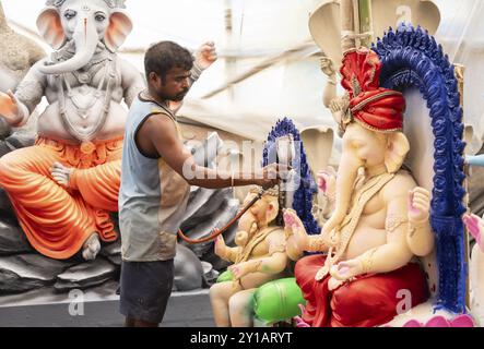 Un artigiano decora un idolo della divinità indù con testa di elefante Ganesha in un laboratorio in vista del festival Ganesh Chaturthi il 5 settembre 2024 a G. Foto Stock