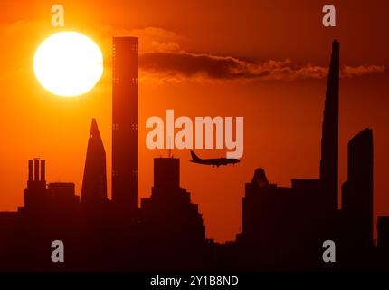 Flushing Meadow, Stati Uniti dichiarato. 5 settembre 2024. Gli aeroplani passano mentre il sole tramonta dietro lo skyline di Manhattan dalla cima dell'Arthur Ashe Stadium ai campionati US Open di tennis 2024 all'USTA Billie Jean King National Tennis Center giovedì 5 settembre 2024 a New York. Foto di John Angelillo/UPI credito: UPI/Alamy Live News Foto Stock