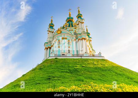 Kiev, Ucraina - 23 agosto 2024: La chiesa di Sant'Andrea si erge maestosamente su una collina verde contro un cielo blu brillante, mostrando una splendida architettura e vi Foto Stock