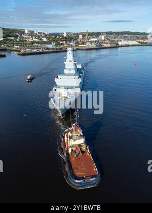 Greenock, Scozia, Regno Unito. 5 settembre 2024. Viste aeree della fregata HMS Cardiff Type 26, navigando oltre la nave da crociera Queen Mary 2 a Greenock, in rotta da Glenmallan al cantiere BAE sul fiume Clyde a Scotstoun a Glasgow. La fregata è stata portata a Glenmallan per essere lanciata in acque profonde e ora sarà allestita presso il cantiere navale di Scotstoun. PIC; Iain Masterton/Alamy Live News Foto Stock