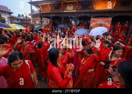 Le donne indù nepalesi a digiuno ballano nei locali del tempio Pashupatinath a Kathmandu, Nepal, il 6 agosto 2024, in occasione della festa di Teej. Secondo la tradizione, le donne in questo terzo giorno della metà oscura del mese lunare che cade nel mese nepalese di Bhadra osservano il digiuno e desiderano una vita prospera mentre osservano la festa. Secondo lo "Skanda Puran" (una scrittura religiosa degli indù), questo festival prende il nome di "Haritalika Teej" come è in questo giorno nel "Satya Yug" (epoca d'oro della verità) che la figlia dell'Himalaya, Parvati, è nascosta dalle sue cameriere Foto Stock