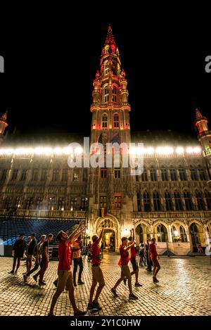 Tifosi che festeggiano davanti al municipio illuminato di Bruxelles - Belgio Foto Stock