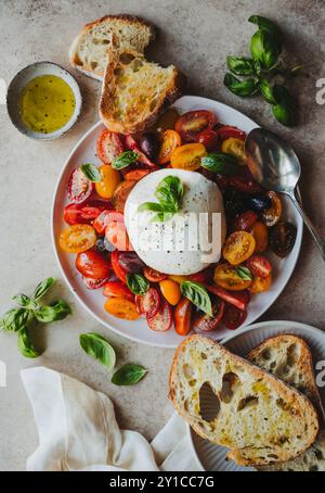 Sopra di piatti di burrata, pomodori, basilico e pane. Foto Stock