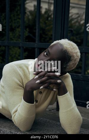 Giovane donna nera bionda all'aperto. È in polo giallo Foto Stock