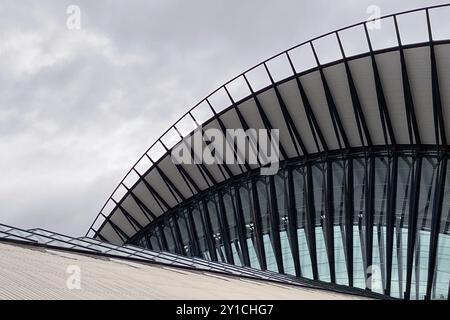 Vista del tetto di un grande edificio moderno in una giornata nuvolosa, dettagli architettonici di strutture brutali in acciaio, cemento e vetro Foto Stock
